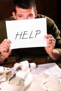 Man paying bills and holding up "Help" sign 