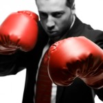 Man in suit with red boxing gloves
